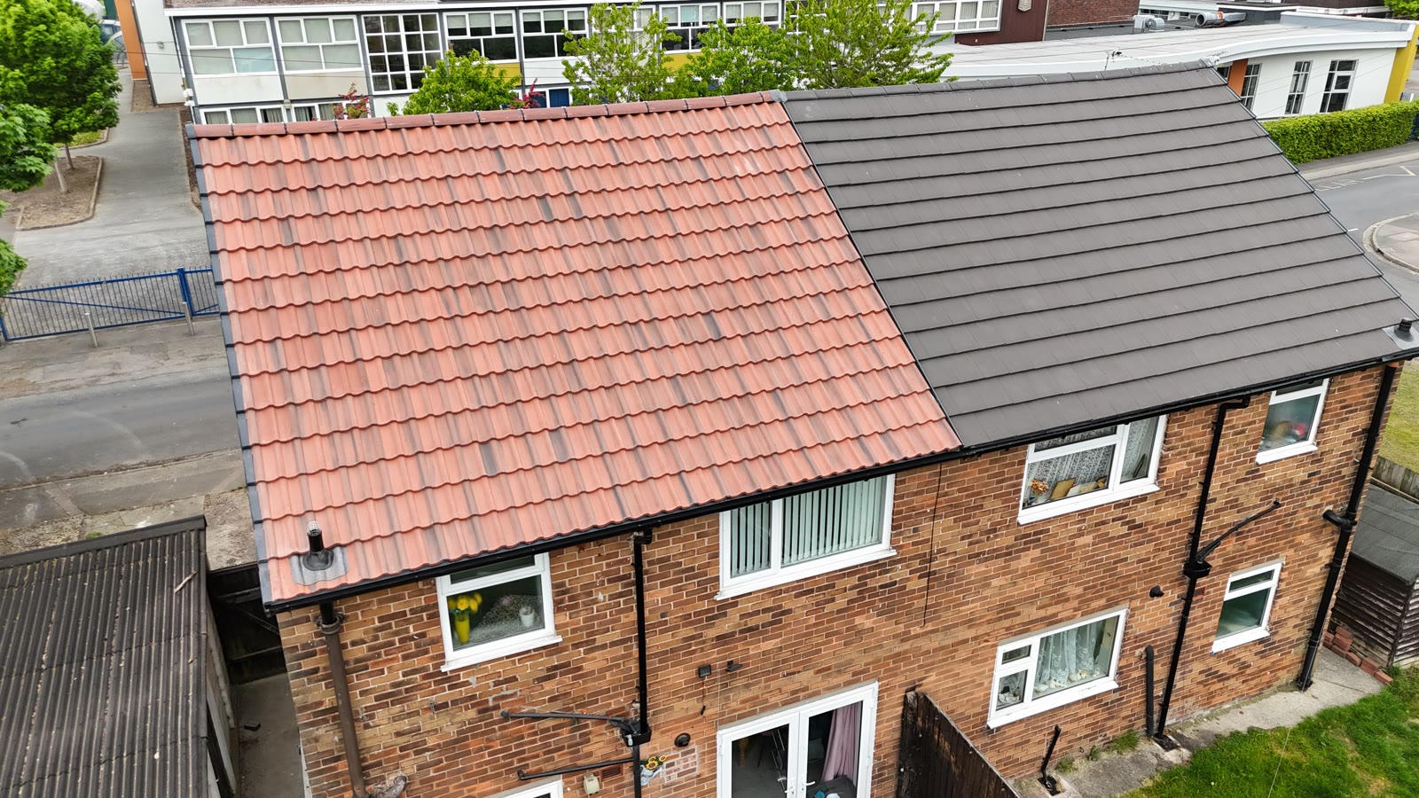 House roof half in terracotta pantiles and half in new dark flat tiles